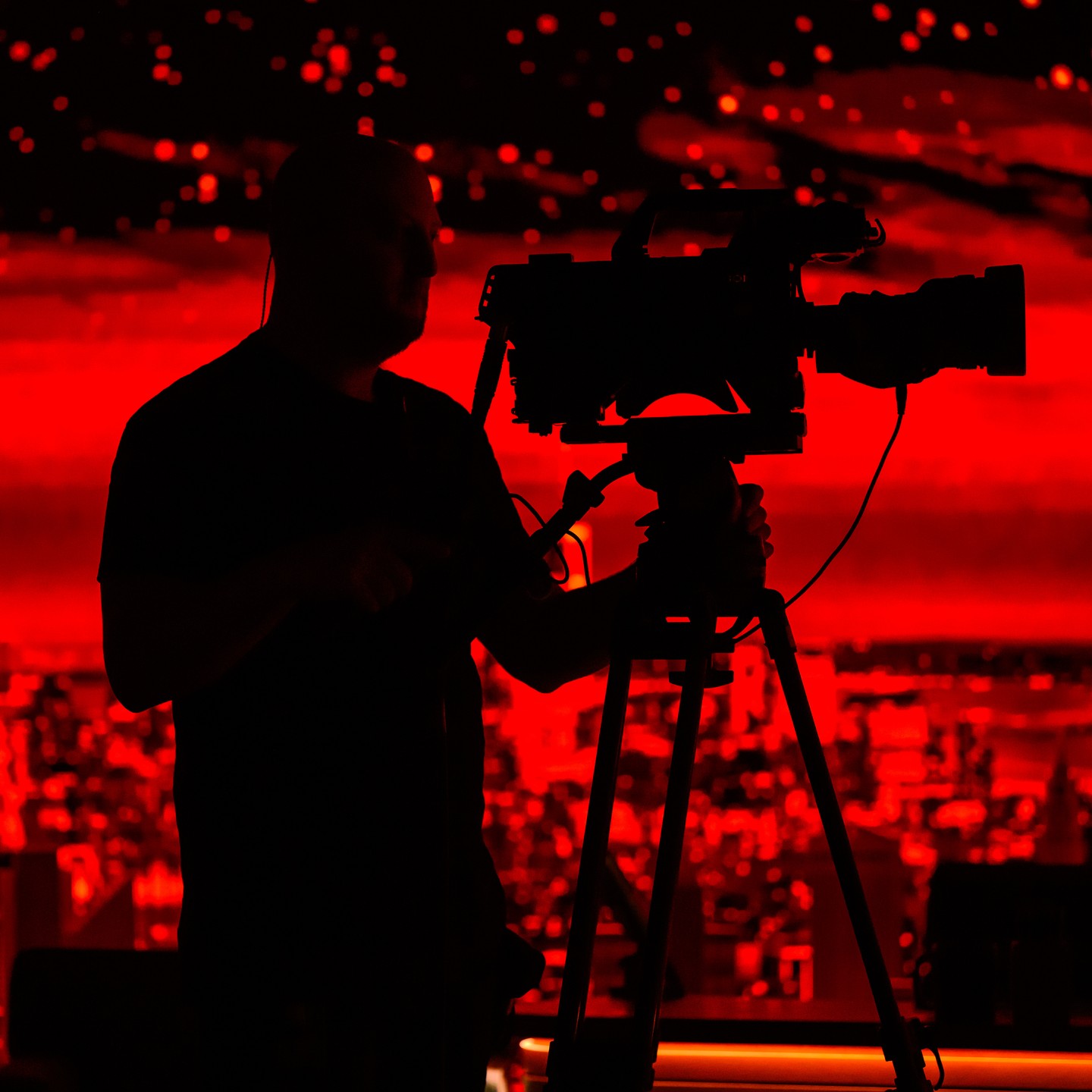 A snap from music rehearsal this morning with camera op Sean. Music today on @fallontonight is the legend Lenny Kravitz, and they turned the screens in the studio red for his performance. Camera blocking/rehearsal had just wrapped and I saw this just before the studio lights came up, but loved the stark silhouette against the deep red of the screen.